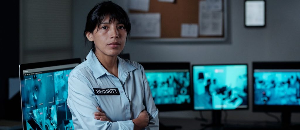 a security officer in front of a CCTV footage monitor