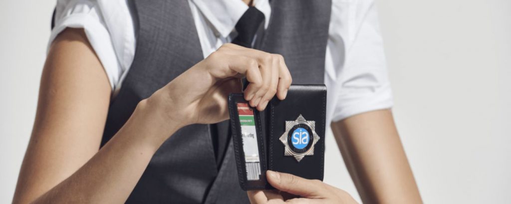 a security officer holding her SIA badge