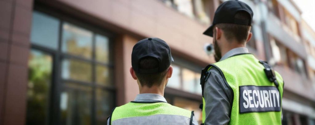 two security officers facing a building